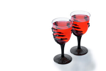 Halloween spooky red cocktail in skeleton hand glass isolated on white background. Copy space