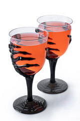 Halloween spooky red cocktail in skeleton hand glass isolated on white background