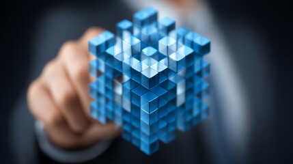 A hand interacts with a complex, translucent cube constructed from smaller blocks, symbolizing data manipulation and interconnected systems in a modern, abstract visual.