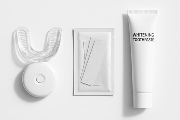 Teeth whitening kit with strips, tray, and whitening toothpaste on white background.