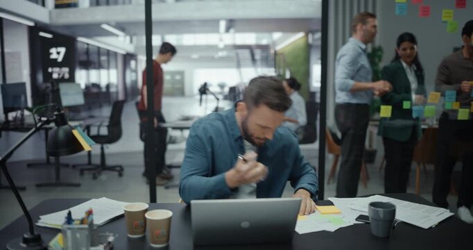 Tired Manager Completing a Difficult Financial Report Before Deadline, Feeling Overwhelmed and Wanting to Sleep. Stressed Out Specialist Working on a Laptop Computer Behind a Desk