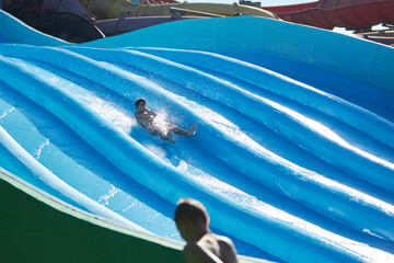 Boy enjoys water slide at aqua park