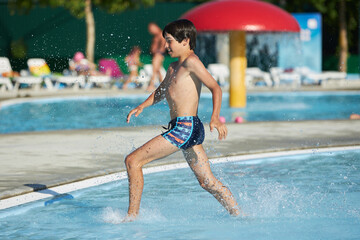 Young boy enjoying fun at a water park © justoomm