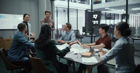 Marketing Department Managers Presenting a New Successful Strategy on a Large Screen. Colleagues Watch with Interest, Agree on Commercial Points, Celebrate with a Group High Five