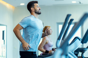 Man and woman running on treadmill at gym.