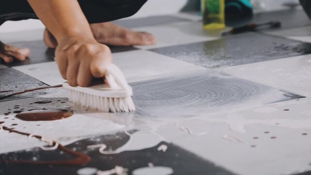Close up of a modern microfiber mop with fluffy white strands cleaning a shiny marble floor in a bright contemporary home