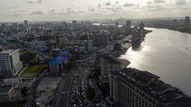 Aerial view of the bustling cityscape where the gleaming buildings meet the sun-kissed waters of the lagoon, Lagos, Lagos, Nigeria.