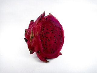 A close-up of a half dragon fruit shows the vibrant pink flesh with small black seeds. Isolated against a white background, it showcases the fruit's texture and color