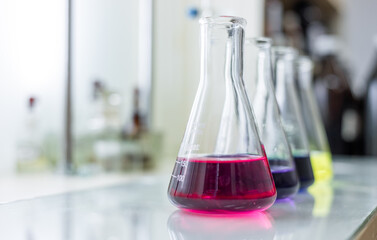 Chemistry laboratory glassware with colour liquids. Chemicals in glass flasks. Chemicals in glass tubes and glass cups, colorful liquid.