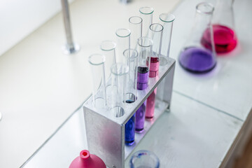Laboratory analysis. Flask and test tubes on white table indoors, closeup. Laboratory test-tubes and retorts. Scientific equipment at laboratory.
