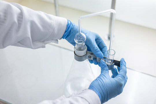 A female chemist assembles a device for distilling and absorbing arsenic in food products.