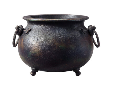 A rustic, dark cast iron cauldron with handles and three legs, isolated on a transparent background