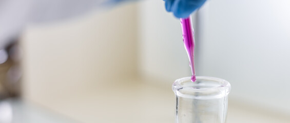 Chemist carries out analysis of water with chemical reagents. Female scientist dripping liquid from...