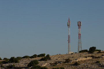 Telecommunication antenna masts for broadcasting television and radio signals on a hill above the town of Lopar on the island of Rab