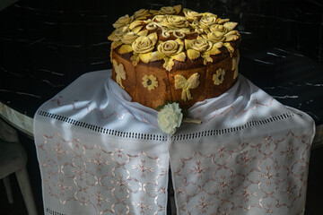 Traditional Ukrainian wedding bread korovai decorated with dough flowers and bows, symbolizing prosperity and unity, served on an embroidered ritual towel
