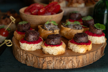 Catering buffet with canape with meat and vegetables on a wooden board. selective focus