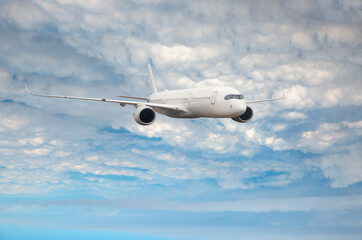 White passenger airplane flying in the sky amazing clouds in the background - Travel by air transport