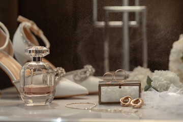 Wedding accessories rings, shoes and perfume on a table