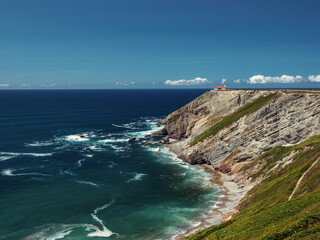 Ocean landscape with a lighthouse in the distance on a summer day