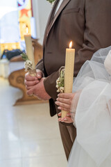 Wedding couple holding candles in church. Bride and groom holding candles