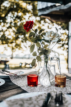 Decorated table with a rose flower. Outdoor setting for dinner