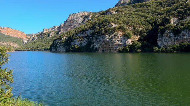 Scenic view of the Sobron Reservoir on the Ebro River, located between Alava and Burgos, Spain. Surrounded by green mountains and dramatic rock formations, this water landscape is a popular