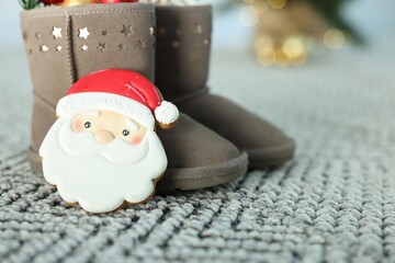 Saint Nicholas day tradition. Boots and gingerbread cookie on floor indoors, closeup
