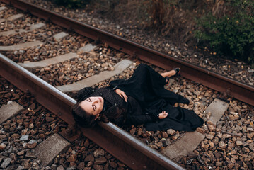 Woman in Historical Outfit Lying on Railway Tracks