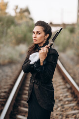 Fototapeta premium Woman Aiming Revolver in Vintage Attire Outdoors