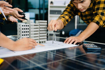 Creative architect projecting on the big drawings with architectural project at construction site at desk in modern office