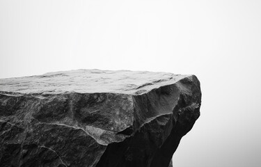 Black and white image of a rock pedestal , isolated on a clean background. Stone texture adds depth, ideal for showcasing products or adding text.
