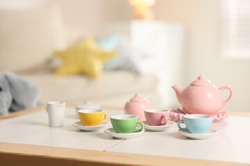 Tea set on white table indoors, closeup with space for text. Child's toy