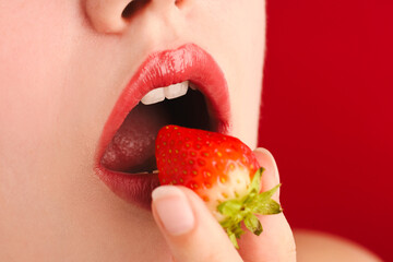 Woman with beautiful lips makeup and strawberry on red background, closeup. Space for text