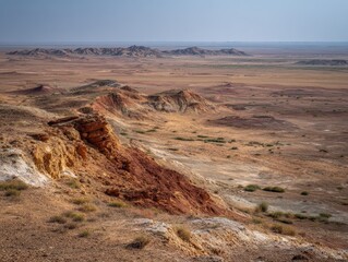 Aerial view of red desert landscape with rolling hills, whiskey rock formations, layered earth strata and sparse vegetation under vast sky, Kaltar desert nature scene.