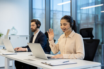 Diverse customer service representatives providing online assistance and communicating with clients via video calls and headsets from a contemporary office environment