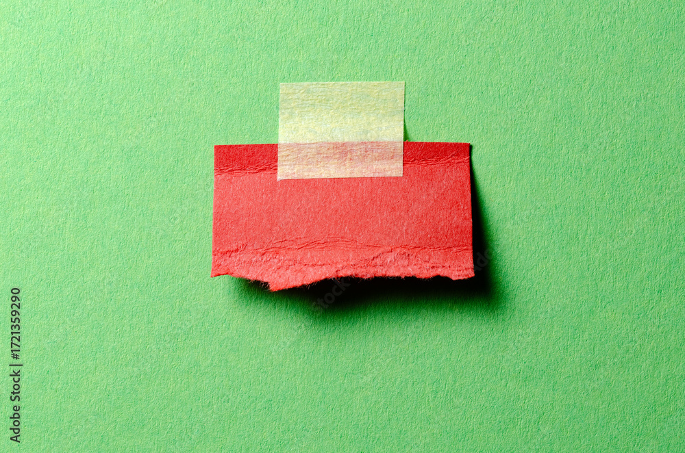 Poster cut out torn piece of red paper note with rough texture edges and adhesive tape with copy space for 