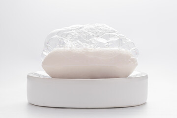 White soap with soap foam on white background. Cleanness concept