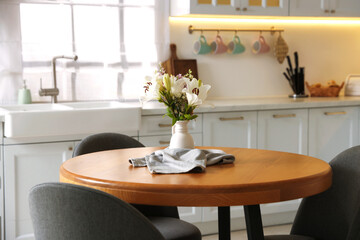 Dining table, chairs and floral decor in kitchen. Interior design