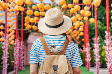 Woman enjoying view of outdoor passage decorated with lanterns