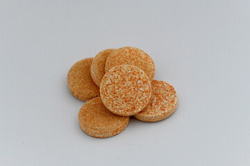 A small, neat pile of effervescent tablets with a speckled orange texture, ideal for representing vitamin supplements, energy, or cold remedies.