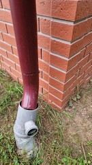 Country house drain near a brick wall
