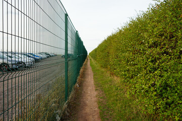 Green fence and hedgerow path alongside East Midlands Airport Trail, Nottinghamshire, England: a tranquil countryside walk