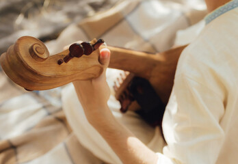 Close-up of man's hands with Ukrainian traditional musical string instrument - kobza. Folk ethnic music, cultural heritage, authentic national clothing. Part of the series