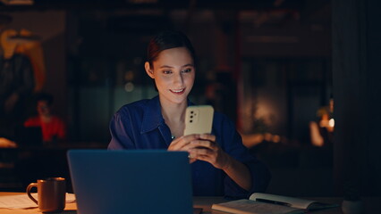 Manager ordering online purchase by cellphone app in night office closeup. 