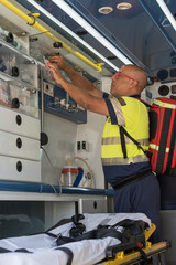 Paramedic preparing medical equipment inside ambulance during emergency © Jorge