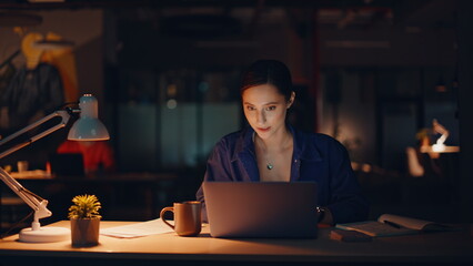 Enthusiastic manager working late evening in office lamp light closeup smiling