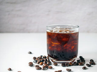 Iced black coffee, iced Americano coffee in glass and roasted coffee beans on white background.