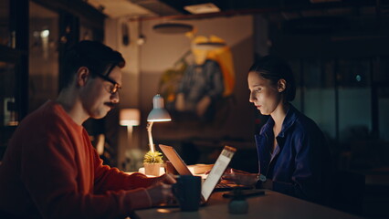 Overworked managers looking laptops at night workspace closeup. Tensed team 