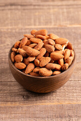 Raw peeled almonds in brown wooden bowl. Organic food concept. 