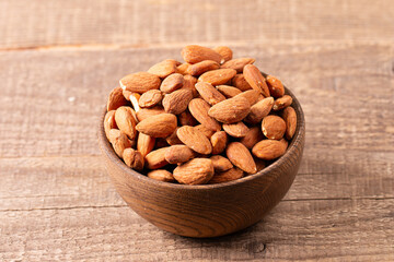 Raw peeled almonds in brown wooden bowl. Organic food concept. 